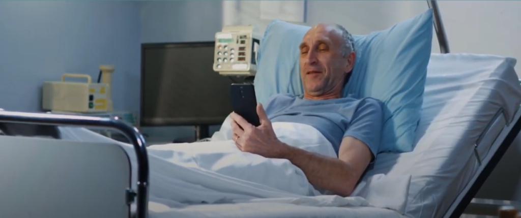 A hospital patient looking at his phone